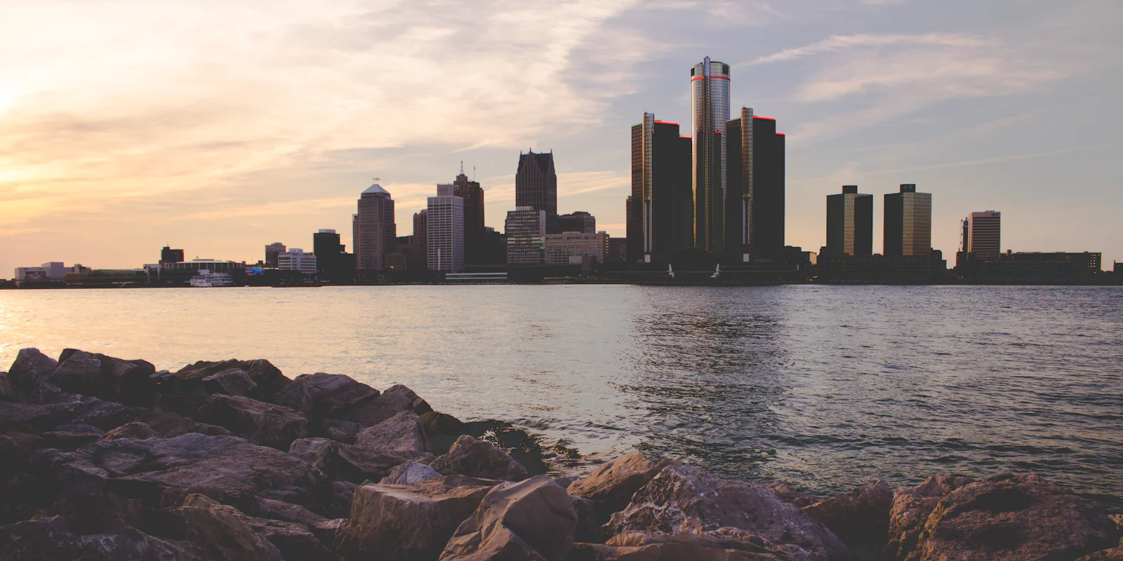 The Detroit skyline across the river, with rocks in the foreground