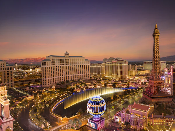 The Las Vegas Strip at dusk, with the Bellagio fountains and the Paris hotel's tower