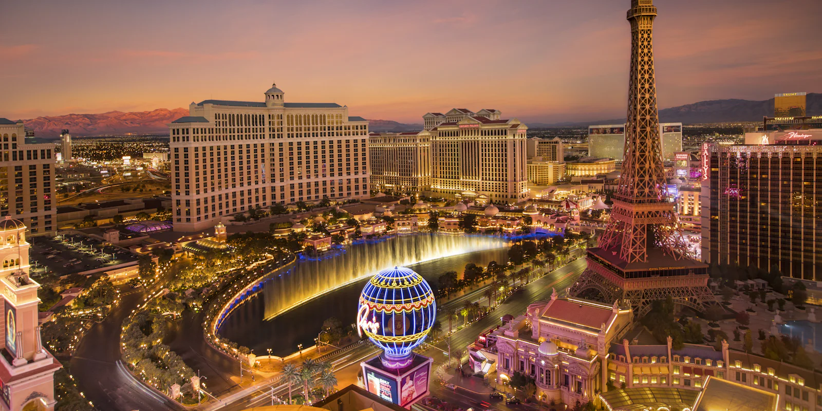 The Las Vegas Strip at dusk, with the Bellagio fountains and the Paris hotel's tower
