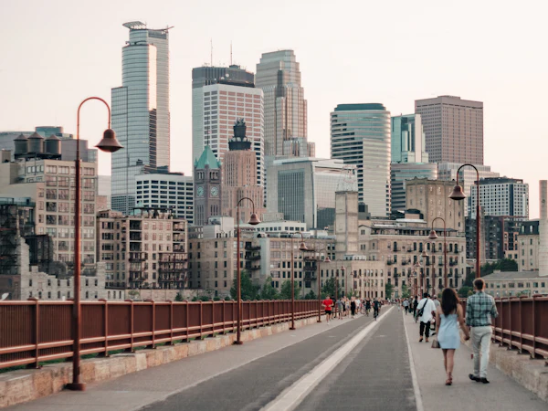 People walking across the Stone Arch Bridge toward downtown Minneapolis