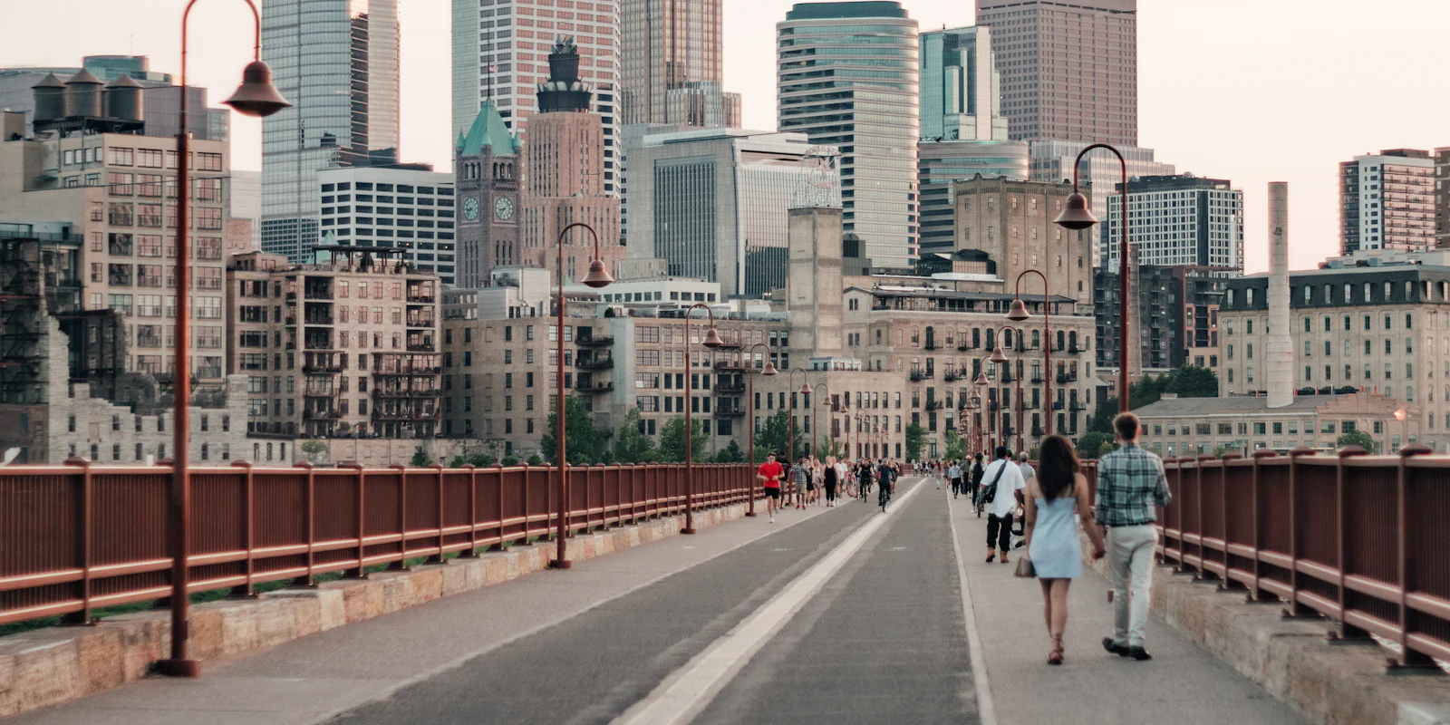 People walking across the Stone Arch Bridge toward downtown Minneapolis